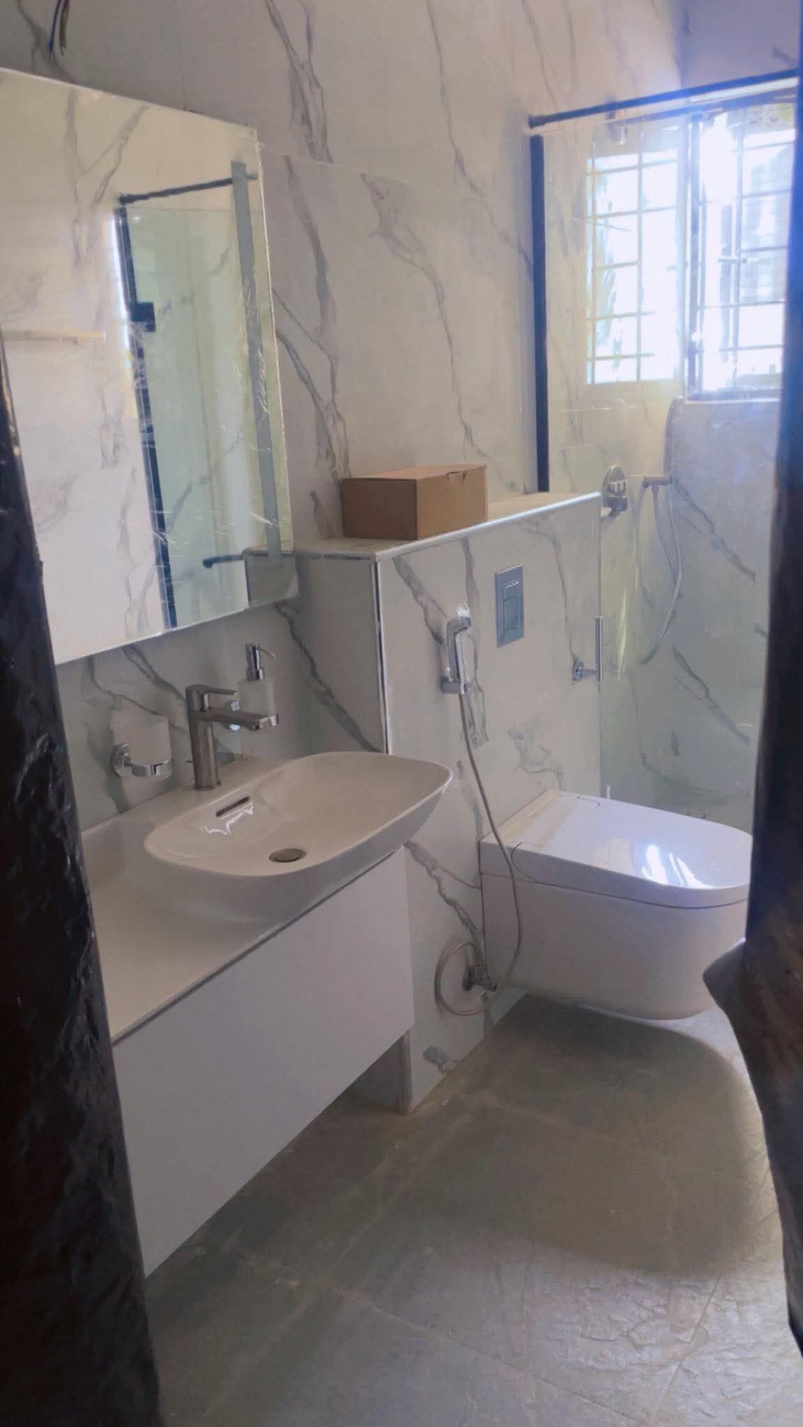 Finished marble bathroom with wall-hung sink and toilet